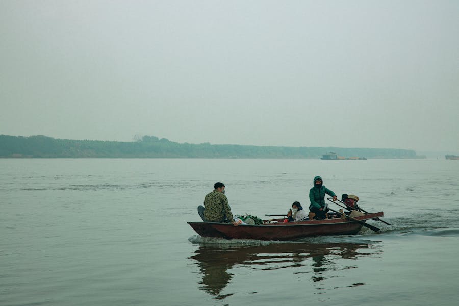 Anglers in a fishing boat on a calm lake at dawn